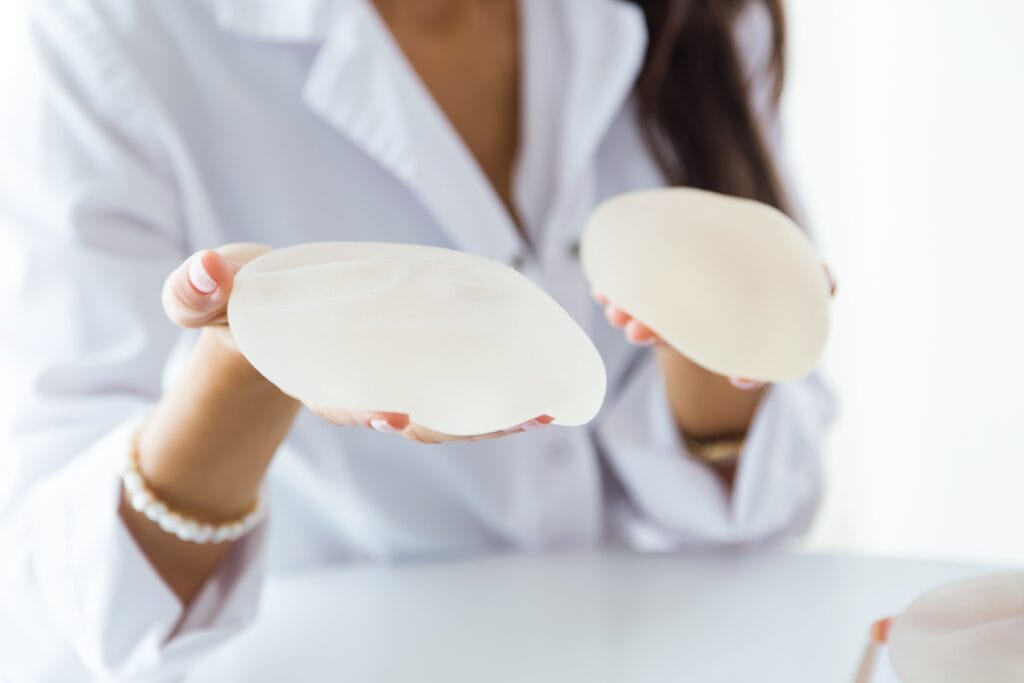 female-doctor-choosing-mammary-prosthesis-office-min